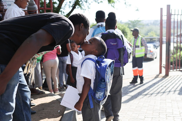 Melusi Masuku gives his son Buhlebemvelo Njibana a good luck kiss before sending him off on his first day of school, 11 January 2023, at Cosmo City Primary School in Diepsloot, Johannesburg, marking the start of the academic year in primary and high schools.