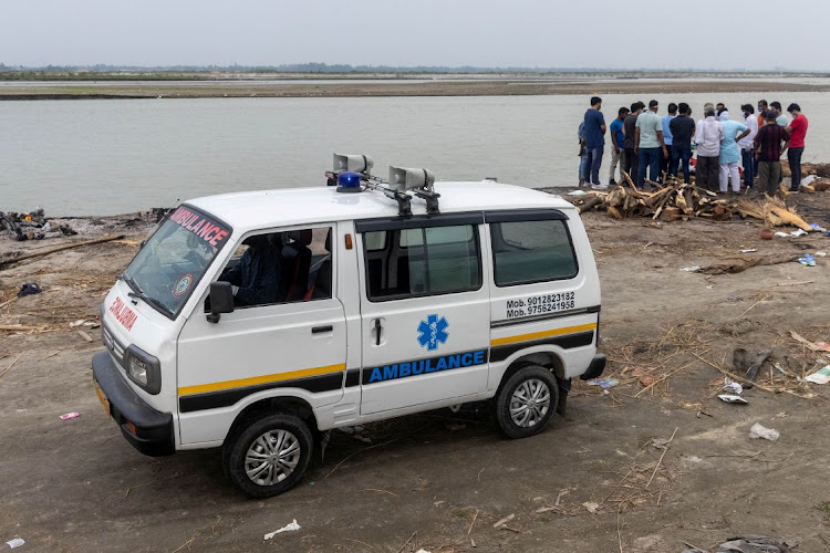 Relatives gather around the body of a man who died from Covid-19, before cremating him on the banks of the river Ganges at Garhmukteshwar in the northern state of Uttar Pradesh, India, on May 6 2021.