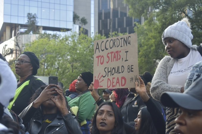 Women bare posters as they protest against gender based violence in Sandton.