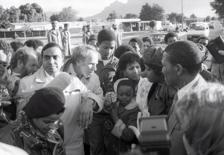 Winnie Madikizela-Mandela and family visiting husband Nelson Mandela at Victor Verster prison in 1988. Dullah Omar is on the left in a light coat. She was allowed to visit her husband in prison rarely, and they were always divided by a glass screen.