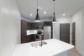 Kitchen with flat panel cabinetry and white quartz countertops