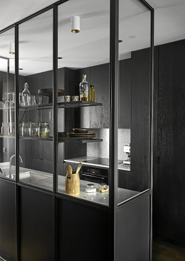 The kitchen in this urban apartment is encased by a wall of steel and glass.