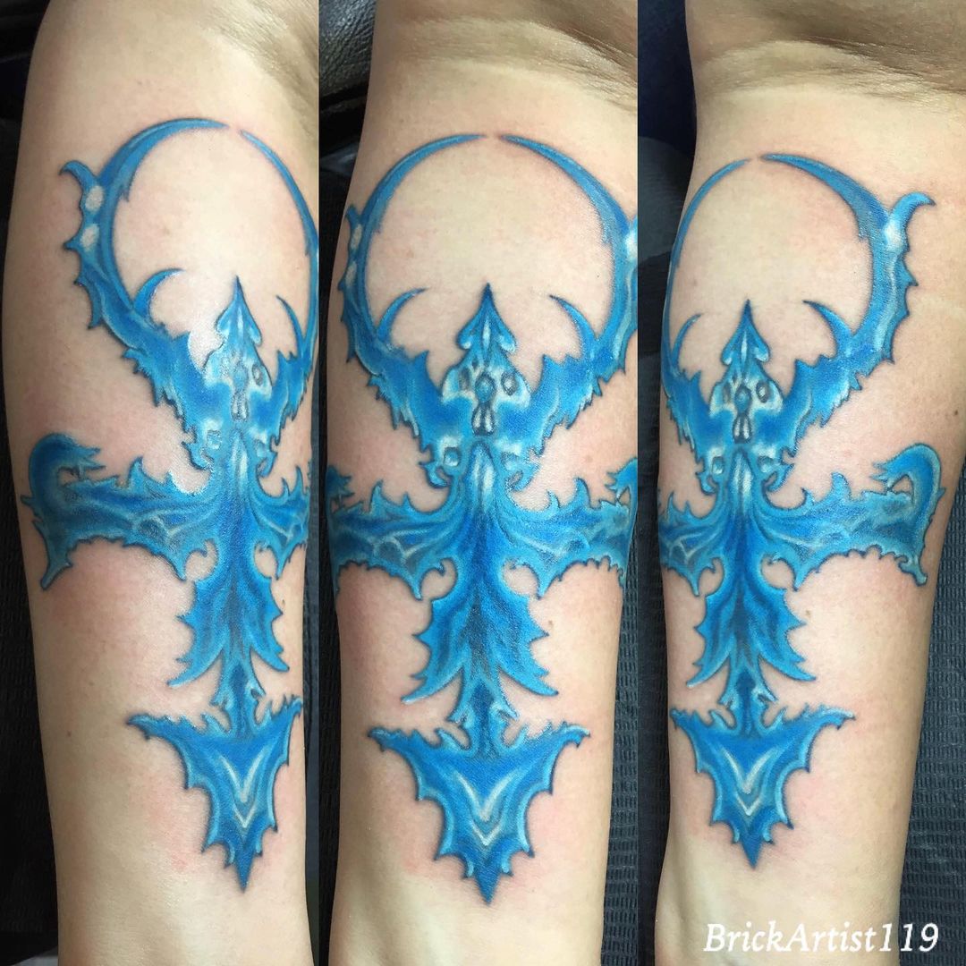 Bold Blue Fire Cross on Arm Tattoo