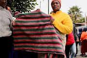 Nozuko Mendela holds up the blanket she received from disaster relief