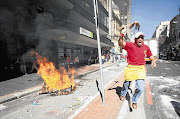 Municipal workers protested yesterday in central Cape Town, looting street vendors' stalls, destroying bins and setting fires. About 2000 striking Samwu members marched from the City Hall along Darling and Adderley streets.