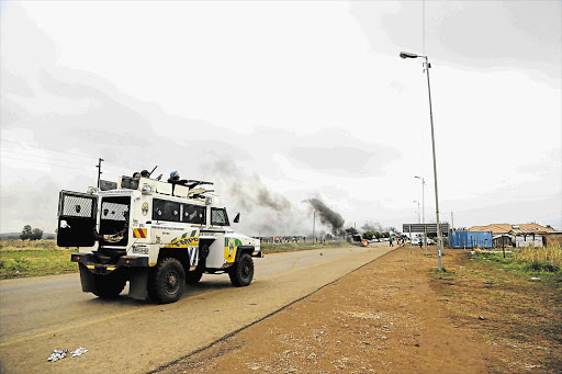 ANARCHY: Officers of the Tshwane Metro Police fire rubber bullets at crowds gathered at Nellmapius, near Pretoria, yesterday. Residents had started to build on vacant land, but the structures were demolished