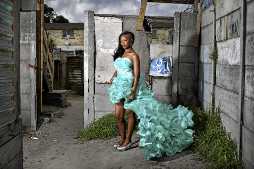 De Wee saved up money for several months, and got some help from her parents, to be able to afford to buy the R3,500 dress she is wearing in this photograph. She wore the dress to her matric dance. In upcoming years she will rent out the dress to other girls graduating from high school, who are in turn having their own matric dances.