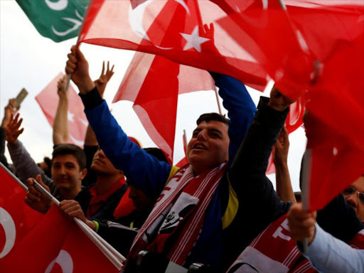 Supporters of Turkish President Tayyip Erdogan wave national flags as they wait for his arrival at the Presidential Palace in Ankara, Turkey, April 17, 2017. /REUTERS