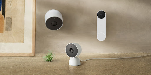 An array of Nest devices, including doorbells, speakers, displays, cameras and more are all laid out on a table and installed on a wall.