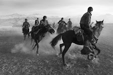 groep mannen te paard met stofwolk