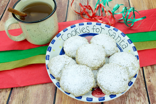 A plate of Pfeffernusse dusted with powdered sugar.