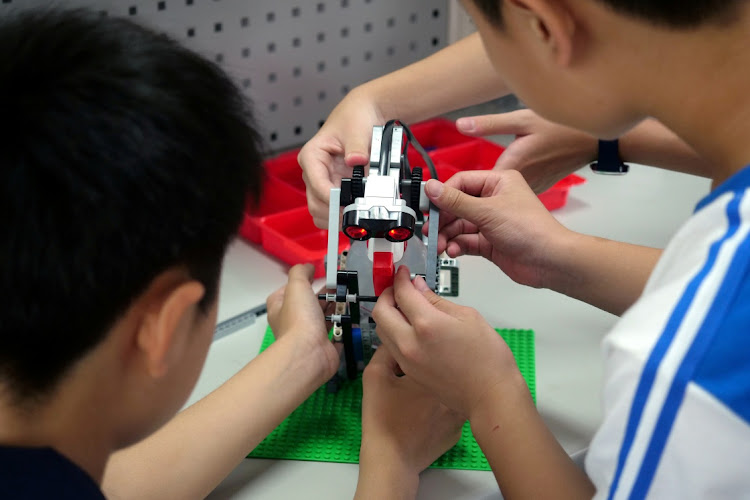 School pupils build a motion sensor-controlled sanitiser dispenser from Lego parts during a workshop in the Taiwanese city of Kaohsiung. Lego has achieved a resurgence in popularity in part due to the Covid-19 lockdowns introduced in many countries.