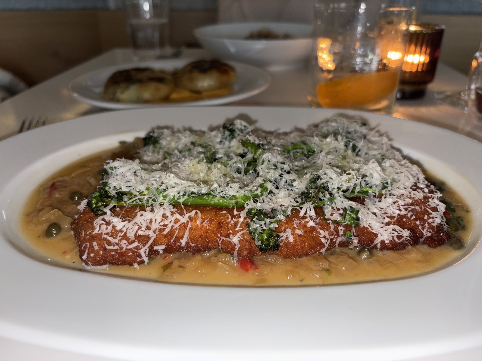 Crispy breaded cutlet with greens and parmesan at Emilia