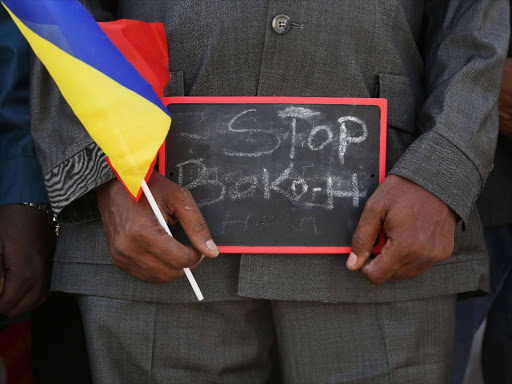 A man holds a sign that reads "Stop Boko Haram" at a rally to support Chadian troops heading to Cameroon to fight Boko Haram, in Ndjamena January 17, 2015. Photo/REUTERS