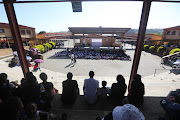 Community members gather to listen to an address by basic education minister Angie Motshekga during the first day of school at Cosmo City Primary.