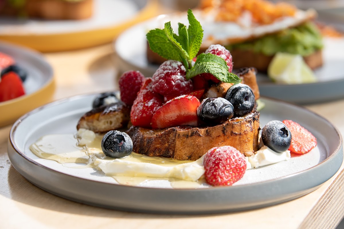 Gluten free french toast with maple syrup, cream cheese and fresh berries.