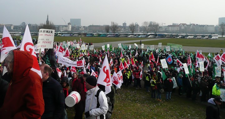 Demonstranten mit Gewerkschaftsfahnen und Transparenten.