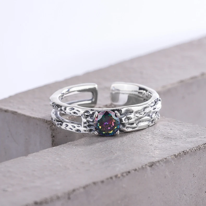 Bague en argent sterling 925 avec zirconiums colorés, motif ajouré et texture irrégulière. Un bijou unique et raffiné.