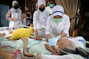 A healthcare worker administers the Pfizer coronavirus disease (COVID-19) vaccine to an elderly woman at her home, in Kuala Langat, Malaysia July 17 2021. 