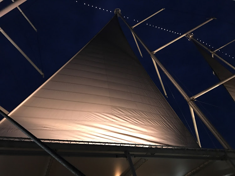 Sails spotlit in the evening breeze on Wind Surf. 