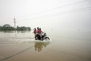 People ride on a bike on a submerged road during a widespread flood in the northeastern part of the country, in Sylhet, Bangladesh on June 19 2022. 