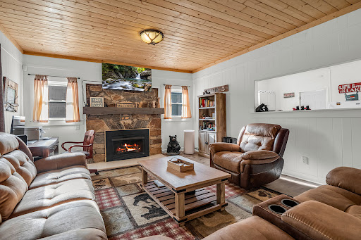 Living room with stone fireplace and sofas - Luxury house for sale in Lake Lure, 2 bedrooms