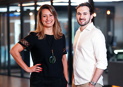 Founders Tatiana and Everton pose in front of an office space