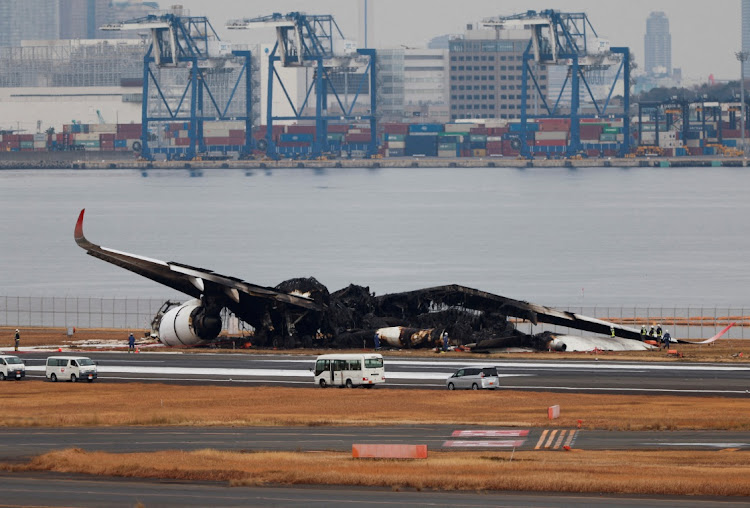 Officials investigate a burnt Japan Airlines Airbus A350 plane after a collision with a Japan Coast Guard aircraft at Haneda International Airport in Tokyo, Japan, on January 3 2024. Picture: ISSEI KATO/REUTERS