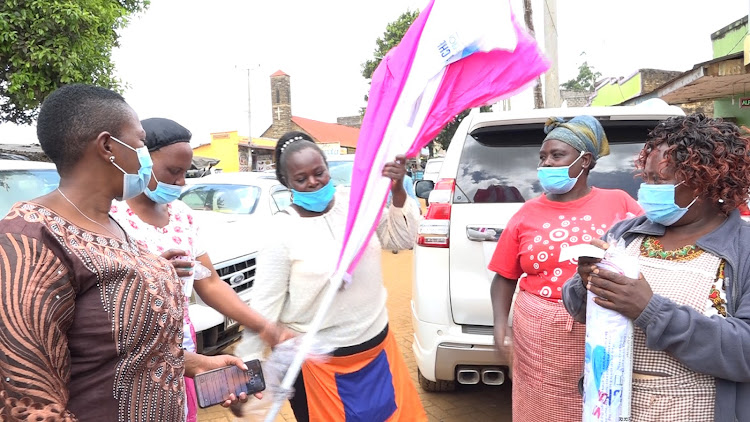 National Assembly Health committee chairperson Sabina Chege issues umbrellas to traders at Kangari in Kigumo on Saturday.
