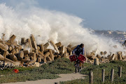 A massive storm with gale force winds drove long lines of huge waves down the coast causing minor damage to infrastructure in the Bay. Pictured here: Sonwabile Henama ducks as huge waves bash against the dolosse next to the N2. 