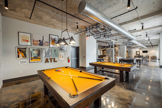 Industrial game room with two pool tables and wall art