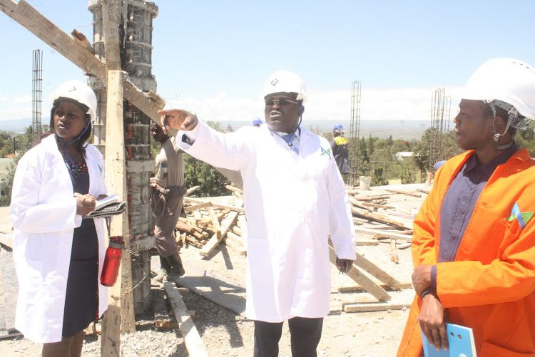 Nakuru Level 5 Hospital Medical Superintendent Dr. Joseph Mburu (C) with the site manager Samuel Muriu inspect works at the outpatient complex.