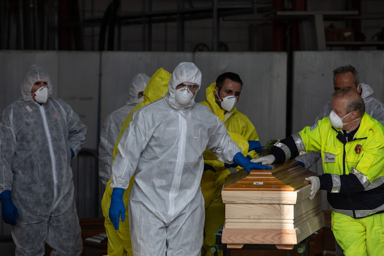 Officers, wearing protective suits, transport coffins in Ponte San Pietro, near Bergamo, Northern Italy. The Italian Army has been brought in to ferry coffins out of Bergamo and its province, amongst Italy's most plagued towns, as its morgue and its crematorium struggle to cope with the surging coronavirus death toll.