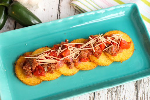 A platter of Nelda's Fried Polenta With Tomato and Sausage Sauce.