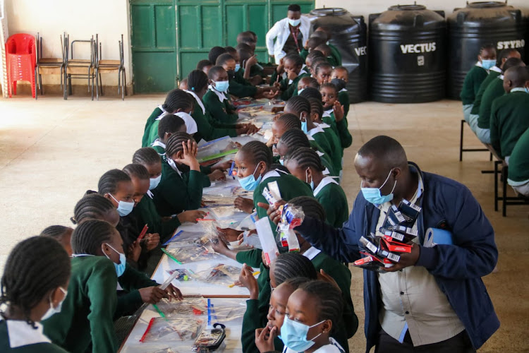 A teacher distributes exam stationery to KCPE candidates at Westlands Primary School during rehearsals on March 4, 2022.