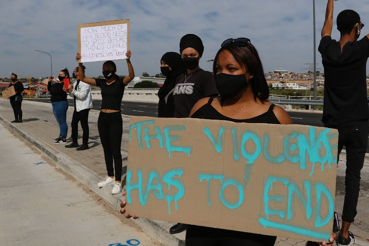 People line Stanford Road in protest against gender-based violence on Saturday.