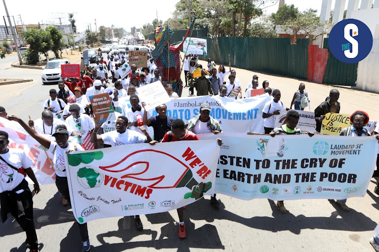 Protesters carry banners as they hold a climate change match by activists, youths and NGOs along Langata Road, Nairobi on September 24, 2022.