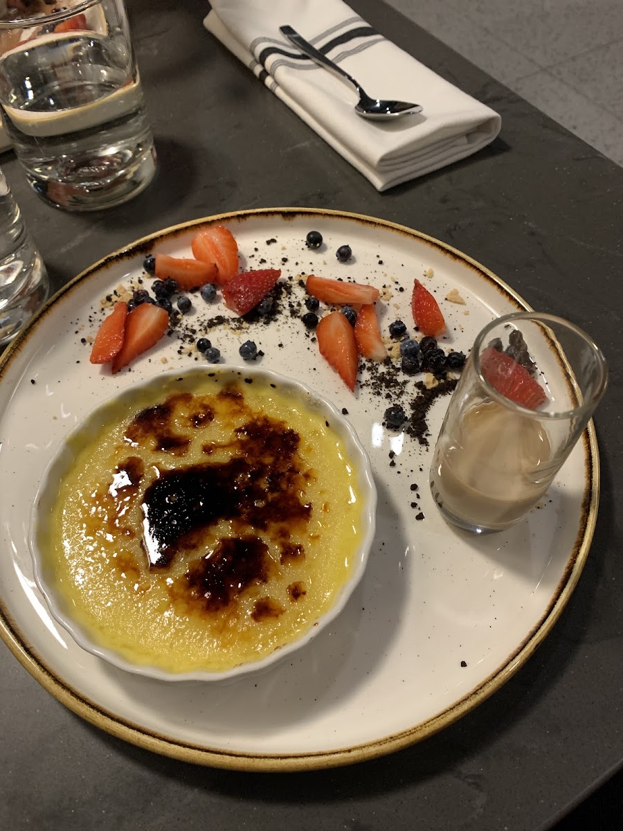 Crème brûlée dessert with cookie crumbles on plate. Be careful.