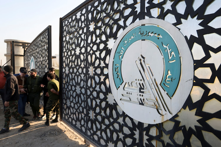 Members of an Iraqi Shi'ite armed group stand guard after an attack by a drone strike on an Iran-backed militia headquarters in Baghdad, Iraq January 4, 2024.