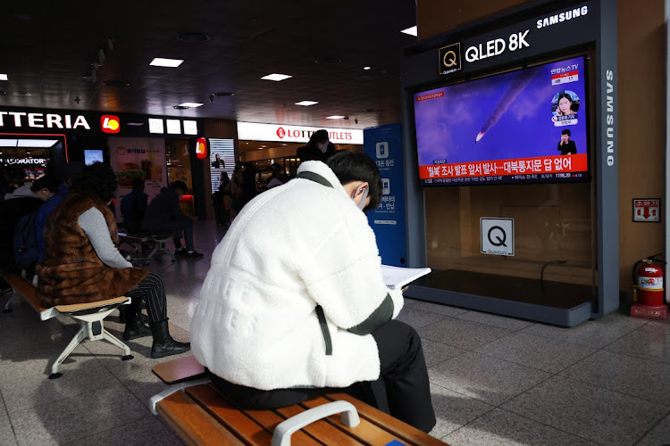 A man sits in front of a TV broadcasting file footage of a news report on North Korea firing a ballistic missile off its east coast, in Seoul, South Korea, January 5, 2022.