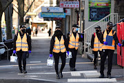 Cleaners walk down a street as the city operates under lockdown in response to an outbreak of Covid-19 in Melbourne, Australia, on September 3 2020. 