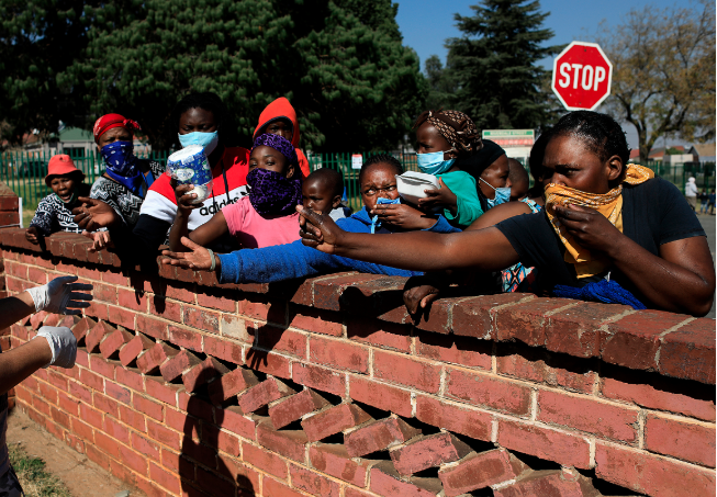 Community members waiting for relief packages from volunteers representing the Hunger has no Religion charity in Johannesburg, on June 9, 2020 .