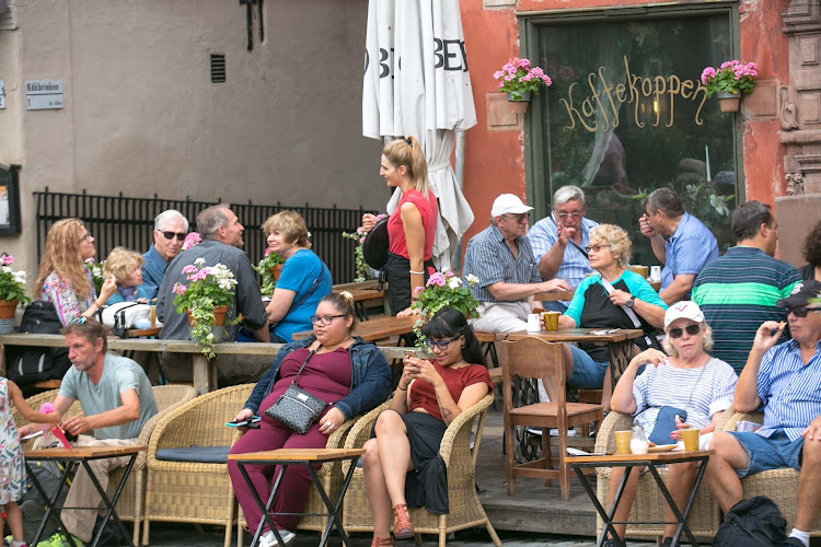 A crowd begins to gather at Kaffekoppen, a cafe on a public square in old Stockholm.