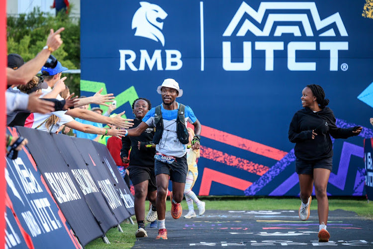 Chris Ngaka storms to the finish of the RMB Ultra Trail Cape Town with his children Will, left, and Trinity. Picture: SAM CLARK