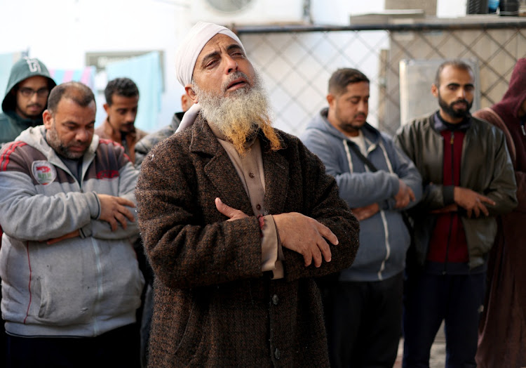 People pray next to dead bodies, including those of Palestinians killed in Israeli strikes in Khan Younis, after they were brought into al-Najjar hospital, amid the ongoing conflict between Israel and Palestinian Islamist group Hamas, in Rafah in the southern Gaza Strip on January 24 2024. Picture: REUTERS/Ibraheem Abu Mustafa