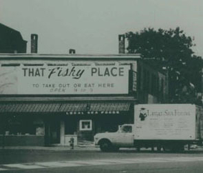 Two story building with sign that reads "That Fishy Place." A truck is parked in front.