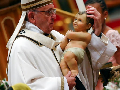 Pope Francis holds a statuette of baby Jesus during the traditional midnight mass in St. Peter's Basilica on Christmas Eve at the Vatican December 24, 2017. /REUTERS