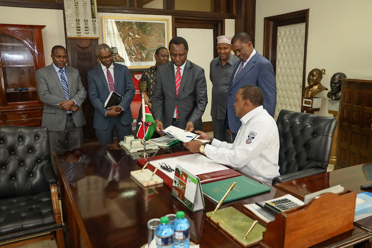 President Uhuru Kenyatta with Cabinet Secretary for the National Treasury Henry Rotichand his Permanent Secretary Kamau Thugge, Speaker of the National Assembly Justin Muturi and the leader of majority in Parliament Aden Duale, Clerk of the National Assembly Michael Sialai and Solicitor General Kennedy Ogeto when he signed the Statute Law (Miscellaneous Amendments) Bill at State House, Nairobi.