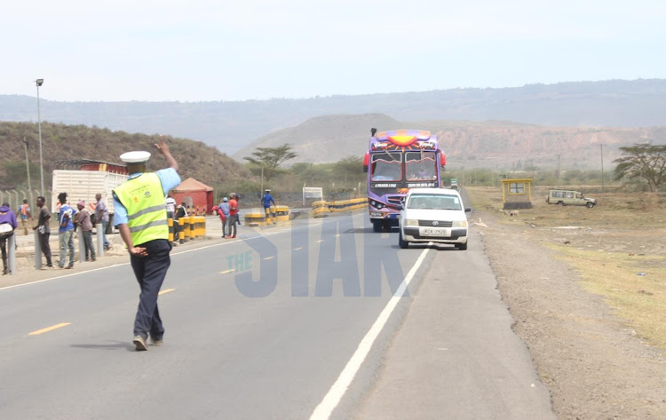 Traffic Police officer controlling vehicles along Mai Mahiu-Narok Road, Mai Mahiu on November 23, 2021.