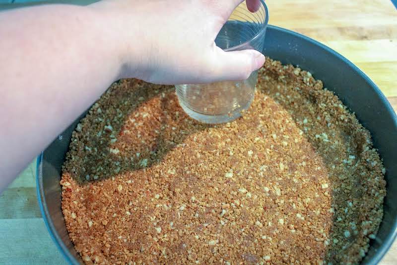 Pressing Crust Ingredients Into A Springform Pan.